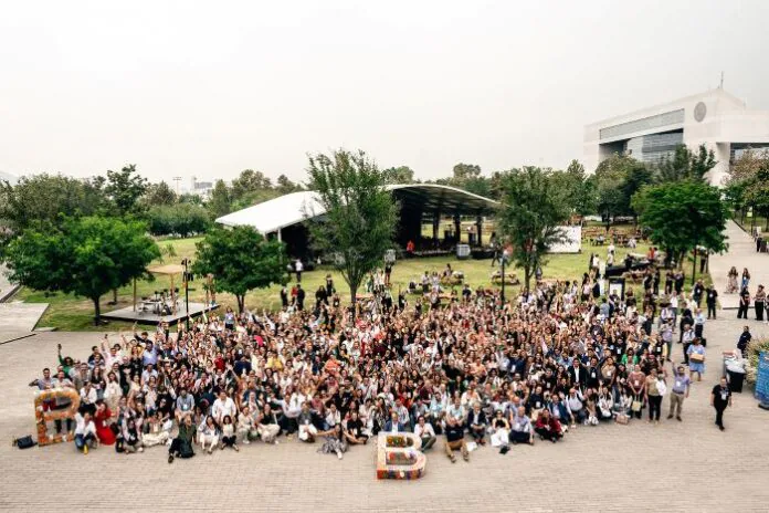 Multitud reunida al aire libre en un campus universitario durante un encuentro del Movimiento B, con participantes formando letras simbólicas en el suelo.