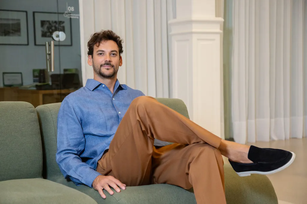 Joaquín Basanta sentado en un sillón en una oficina moderna, fundador y CEO de Agro Sustentable, empresa argentina dedicada al desarrollo de bioinsumos para una agricultura sostenible.